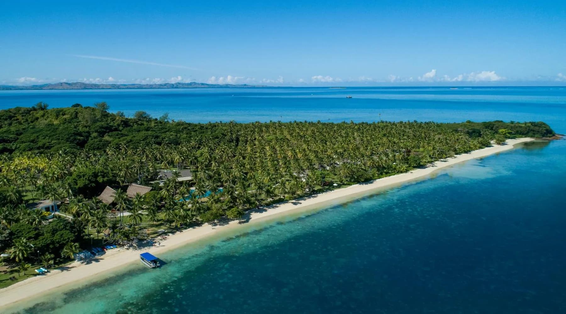 Aerial view of a Mamanuca island resort beside clear blue water