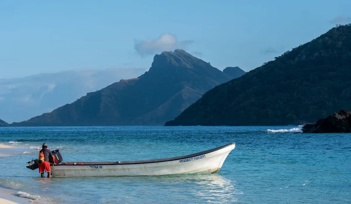 A small boat beside an island shore in Fiji